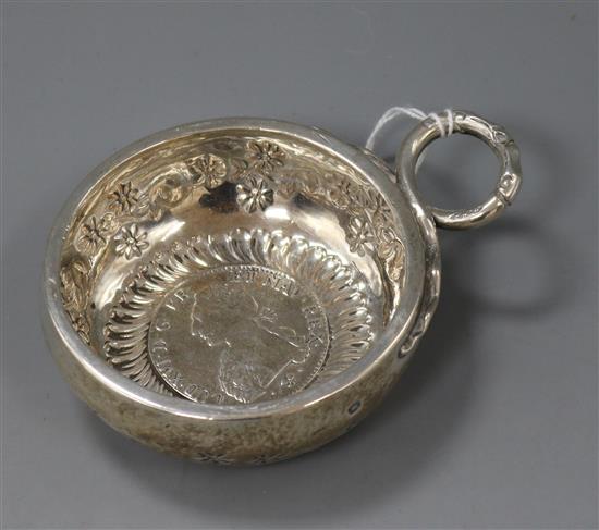 An early 19th century French white metal taste vin with ring handle and inset coin base, 11.2cm inc. handle.